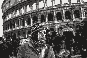 Colosseum, young man, hat, helmet, birds, clouds, eyes, distance.